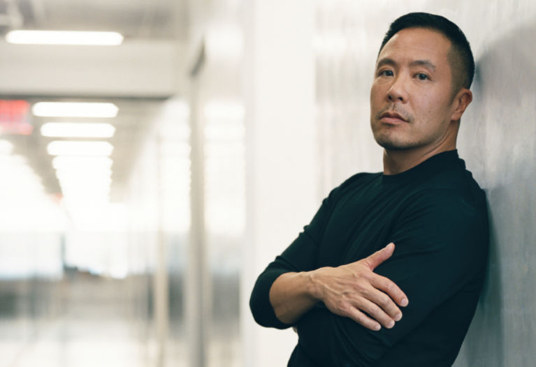 Derek Lam leaning against a wall Derek Lam leaning against a wall