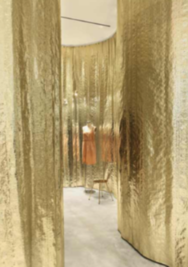 Detail of a store section with golden walls and a mannequin inside Detail of a store section with golden walls and a mannequin inside