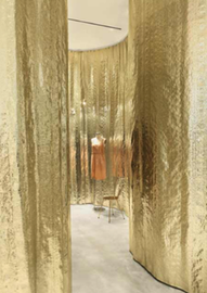 Detail of a store section with golden walls and a mannequin inside Detail of a store section with golden walls and a mannequin inside